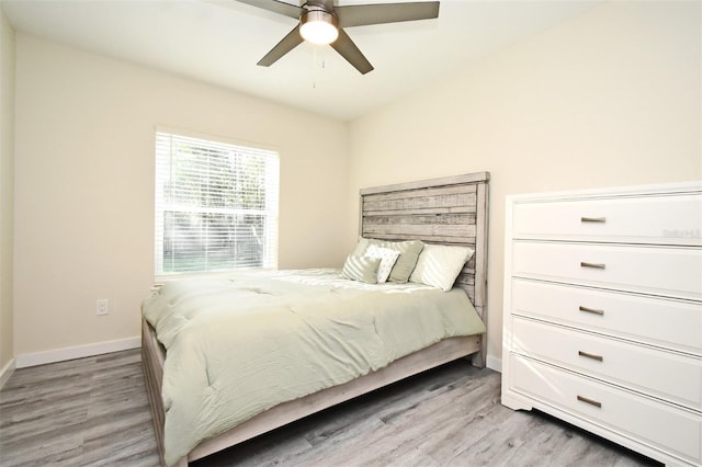 bedroom with ceiling fan, baseboards, and wood finished floors