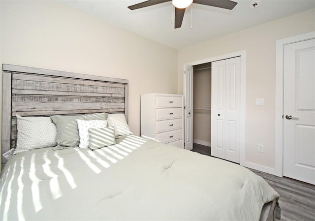 bedroom featuring ceiling fan, a closet, wood finished floors, and baseboards