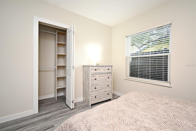 bedroom featuring baseboards and wood finished floors