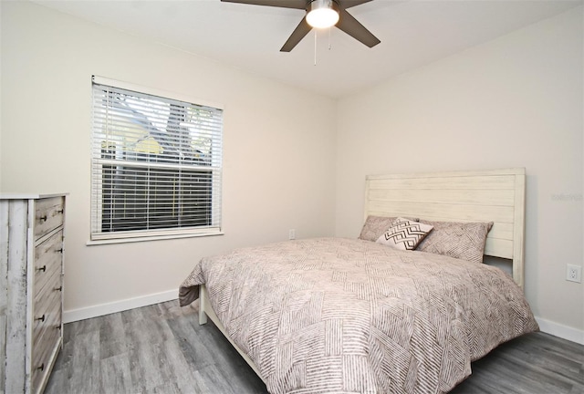 bedroom featuring a ceiling fan, baseboards, and wood finished floors