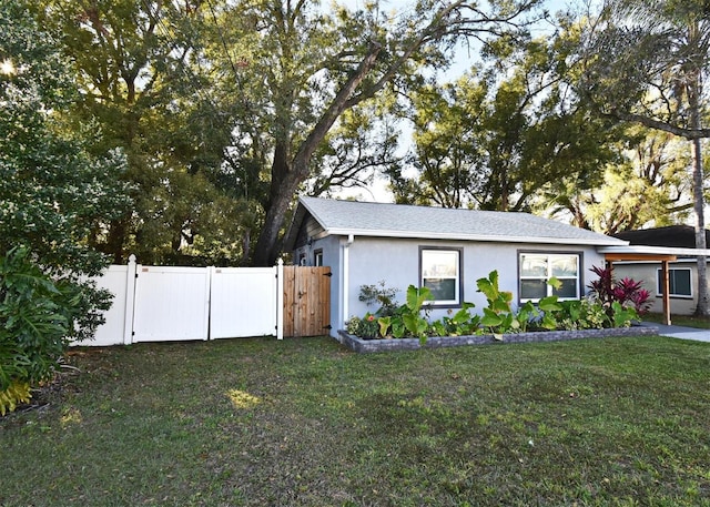 view of front of house featuring a front yard, a gate, fence, and stucco siding