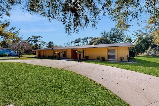 single story home featuring concrete driveway and a front yard