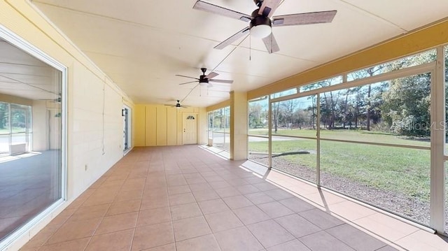 unfurnished sunroom with ceiling fan