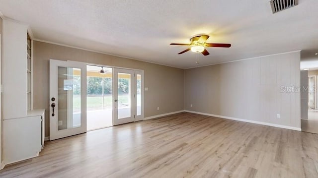 spare room with light wood-style floors, french doors, visible vents, and a ceiling fan