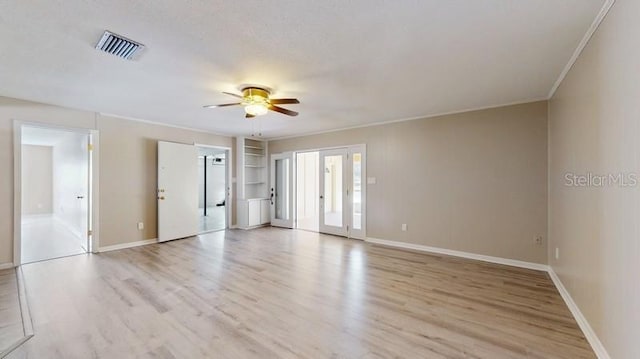 unfurnished room with a ceiling fan, baseboards, visible vents, light wood-style floors, and ornamental molding