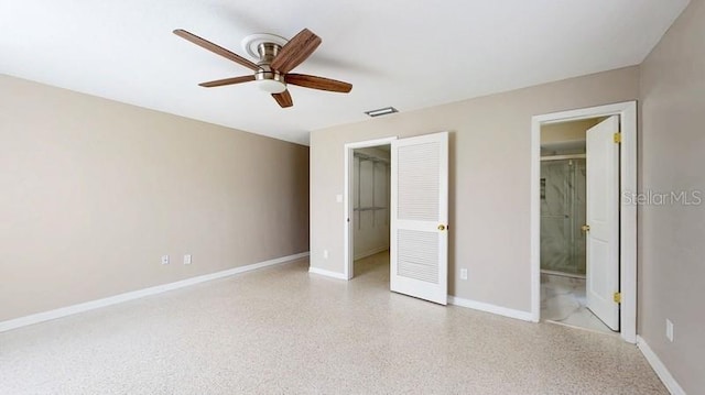 unfurnished bedroom with baseboards, visible vents, connected bathroom, a spacious closet, and light speckled floor