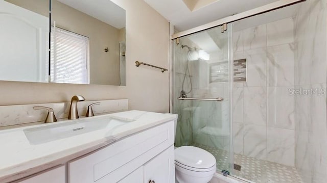 full bathroom with toilet, a marble finish shower, and vanity