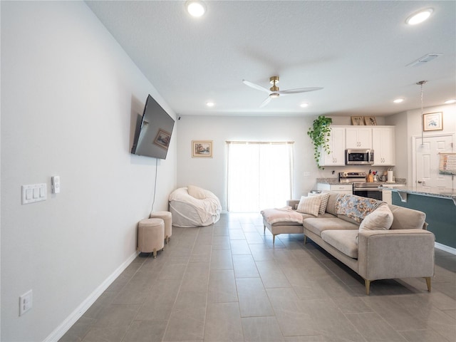 living area with recessed lighting, visible vents, ceiling fan, and baseboards