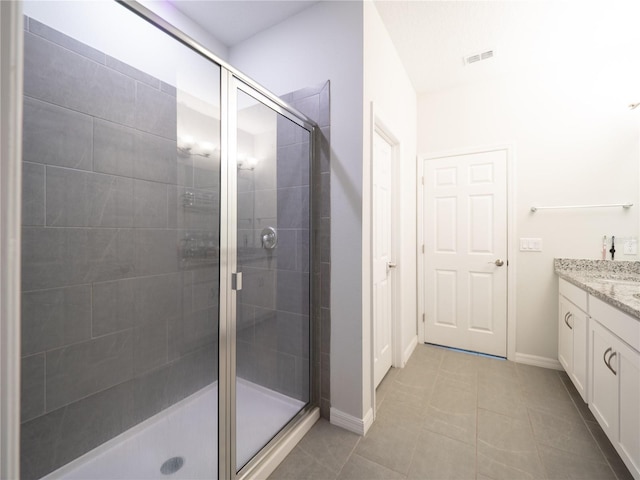 bathroom featuring visible vents, a stall shower, vanity, baseboards, and tile patterned floors