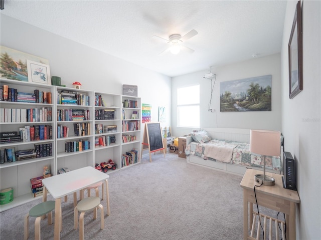 bedroom with a ceiling fan, carpet, and a textured ceiling