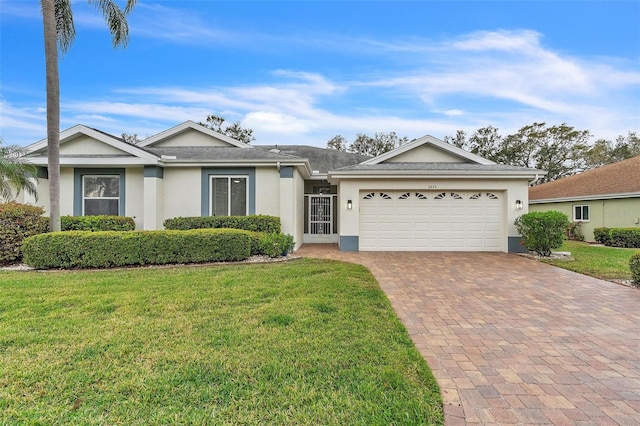 ranch-style house with stucco siding, an attached garage, decorative driveway, and a front lawn