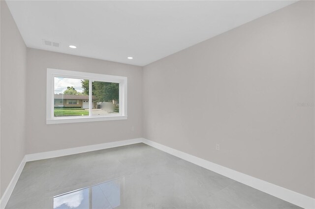 empty room with concrete flooring, recessed lighting, baseboards, and visible vents