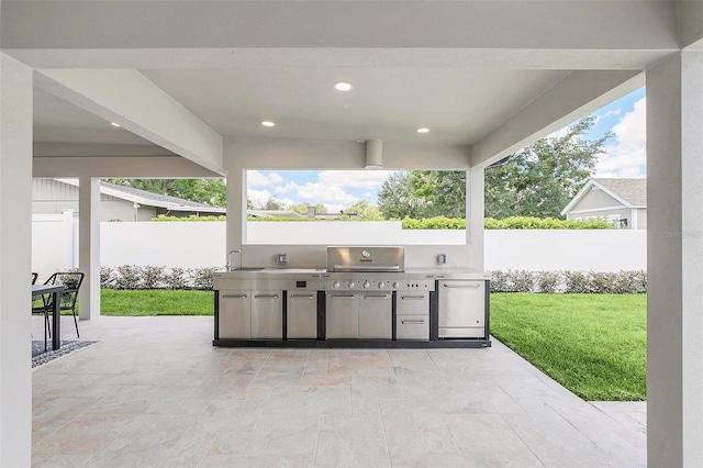 view of patio featuring a grill, an outdoor kitchen, and fence