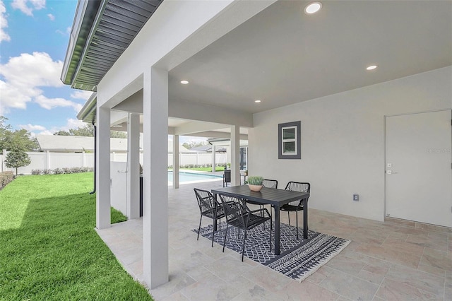 view of patio with a fenced in pool, fence, and outdoor dining space
