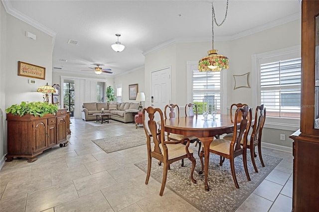 dining room featuring baseboards, a ceiling fan, visible vents, and crown molding