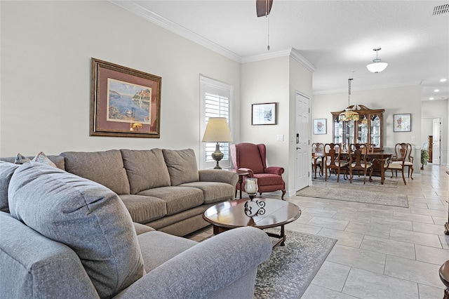 living area featuring light tile patterned floors, visible vents, baseboards, a ceiling fan, and ornamental molding