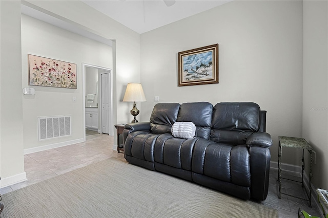 living room featuring a ceiling fan, tile patterned floors, visible vents, and baseboards