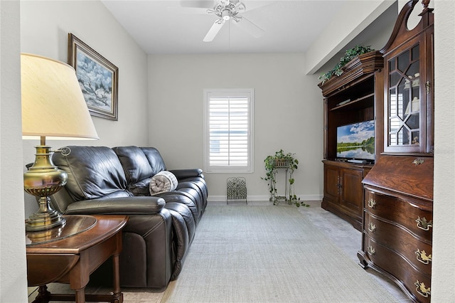 living room featuring baseboards and a ceiling fan