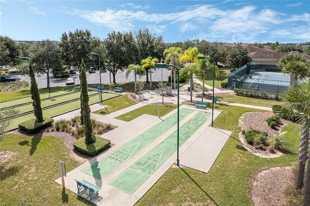 view of property's community with a lawn and shuffleboard