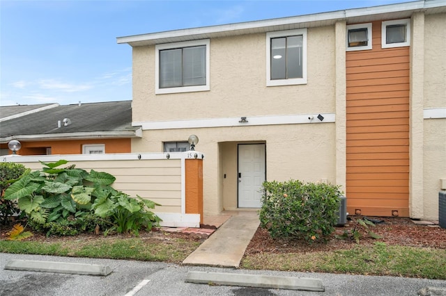 view of property with uncovered parking and stucco siding