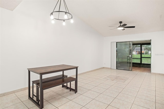 empty room featuring lofted ceiling, light tile patterned flooring, a ceiling fan, and baseboards