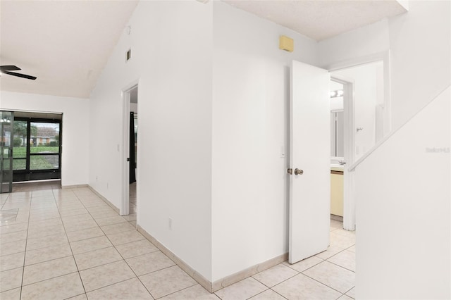 hallway featuring light tile patterned floors, visible vents, and baseboards