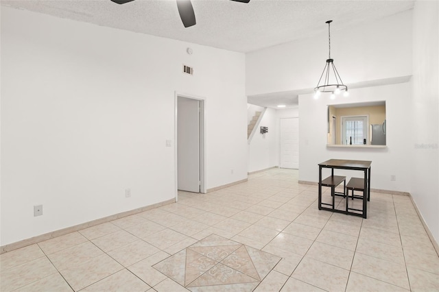 empty room with light tile patterned floors, stairs, baseboards, and a ceiling fan