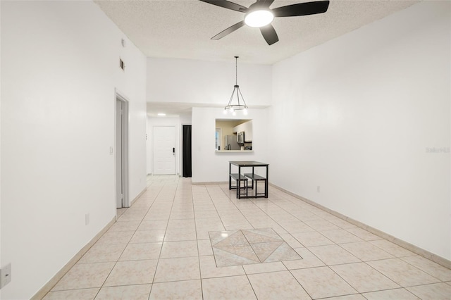 spare room with light tile patterned floors, ceiling fan, a textured ceiling, and lofted ceiling