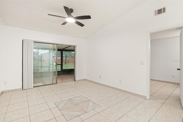 empty room featuring light tile patterned floors, lofted ceiling, visible vents, a ceiling fan, and baseboards