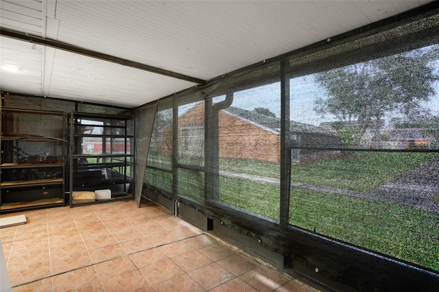 unfurnished sunroom with beamed ceiling