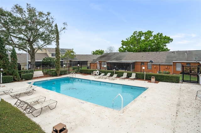 pool with a patio and fence