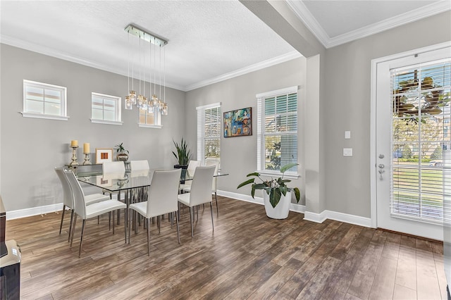 dining room featuring a textured ceiling, a notable chandelier, wood finished floors, baseboards, and crown molding