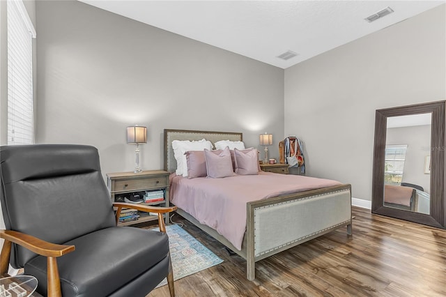 bedroom featuring wood finished floors, visible vents, and baseboards