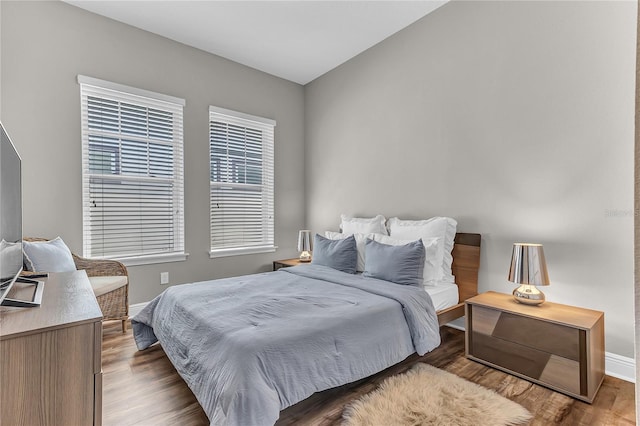 bedroom with baseboards and wood finished floors