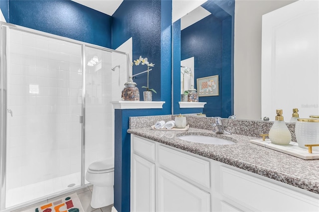 bathroom with a stall shower, a textured wall, vanity, and toilet