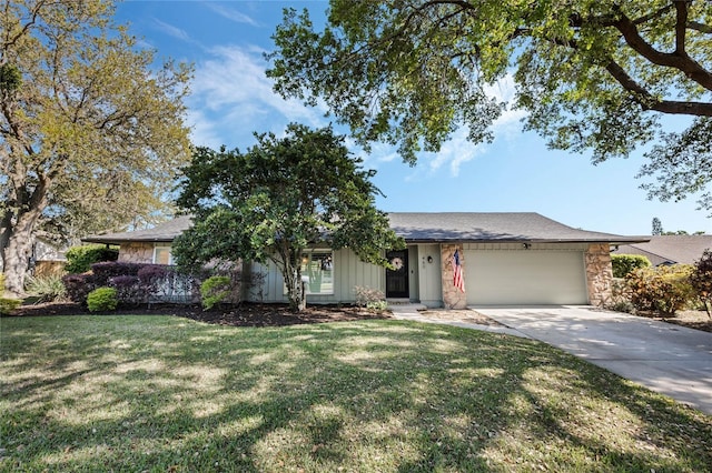 single story home with stone siding, a front lawn, concrete driveway, and an attached garage