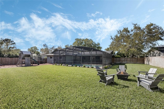 view of yard featuring a fenced in pool, a fire pit, a playground, a lanai, and a fenced backyard