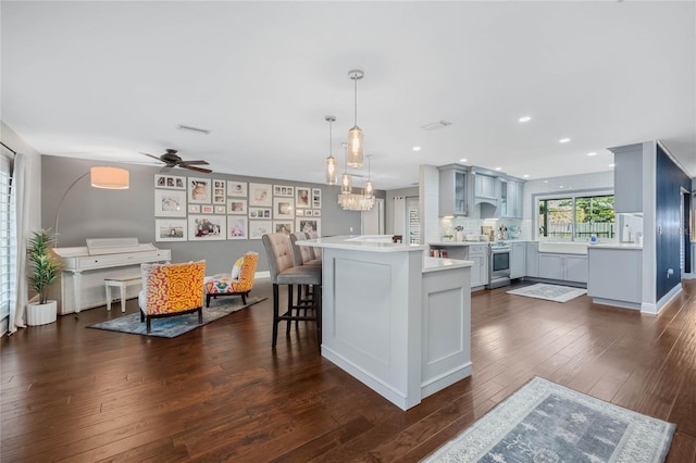 kitchen with dark wood-type flooring, electric stove, a breakfast bar area, light countertops, and glass insert cabinets