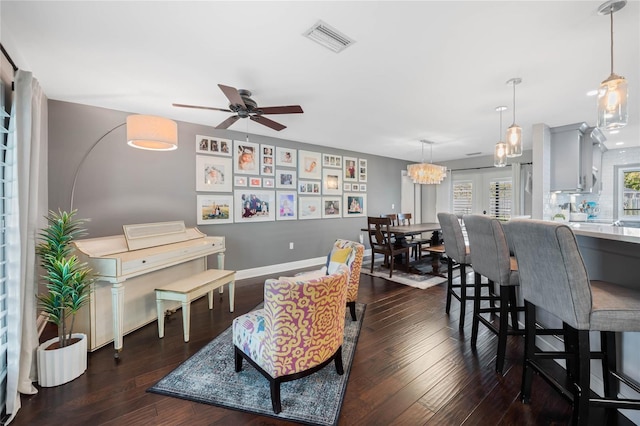 living room with visible vents, baseboards, dark wood finished floors, and a ceiling fan