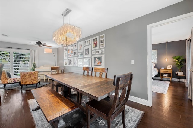 dining area with visible vents, ceiling fan with notable chandelier, baseboards, and hardwood / wood-style floors