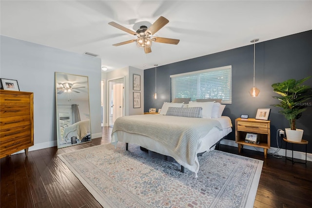 bedroom featuring visible vents, baseboards, ceiling fan, and hardwood / wood-style flooring