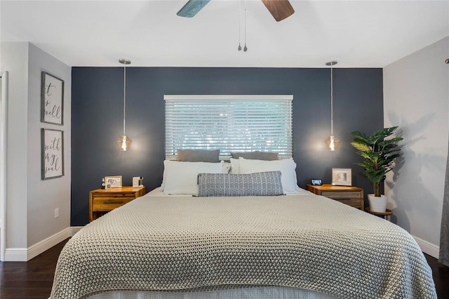 bedroom featuring ceiling fan, baseboards, and wood finished floors