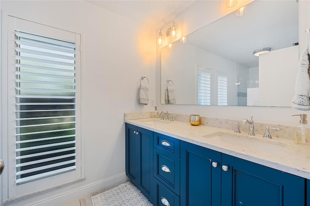 bathroom featuring double vanity, a wealth of natural light, and a sink