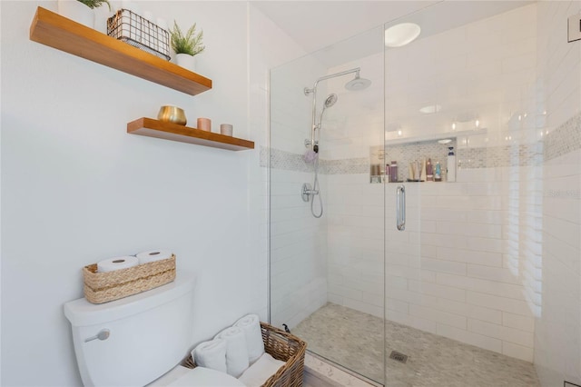 bathroom featuring a shower stall and toilet