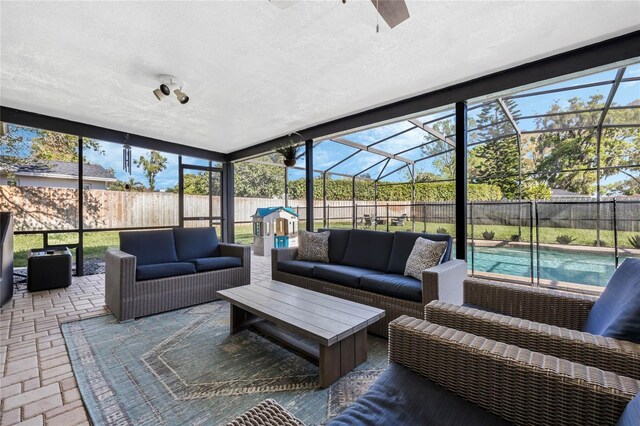 sunroom / solarium featuring a ceiling fan