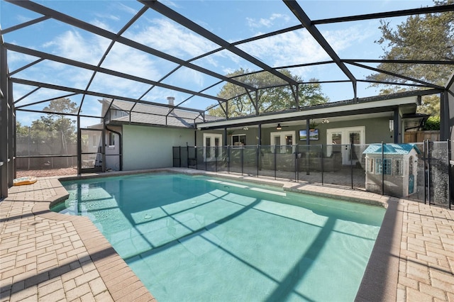 view of pool with glass enclosure, french doors, a patio, and a fenced in pool