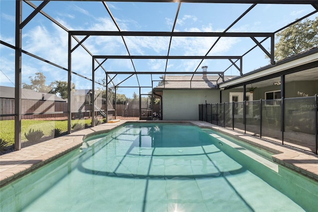 view of swimming pool with glass enclosure, a patio, a fenced in pool, and a fenced backyard