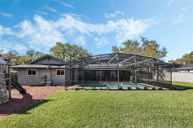 back of property with a fenced in pool, fence, stucco siding, a lanai, and a lawn