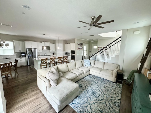 living room featuring stairs, ceiling fan, and dark wood-style flooring