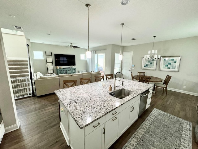 kitchen with stainless steel dishwasher, dark wood finished floors, white cabinets, and a sink